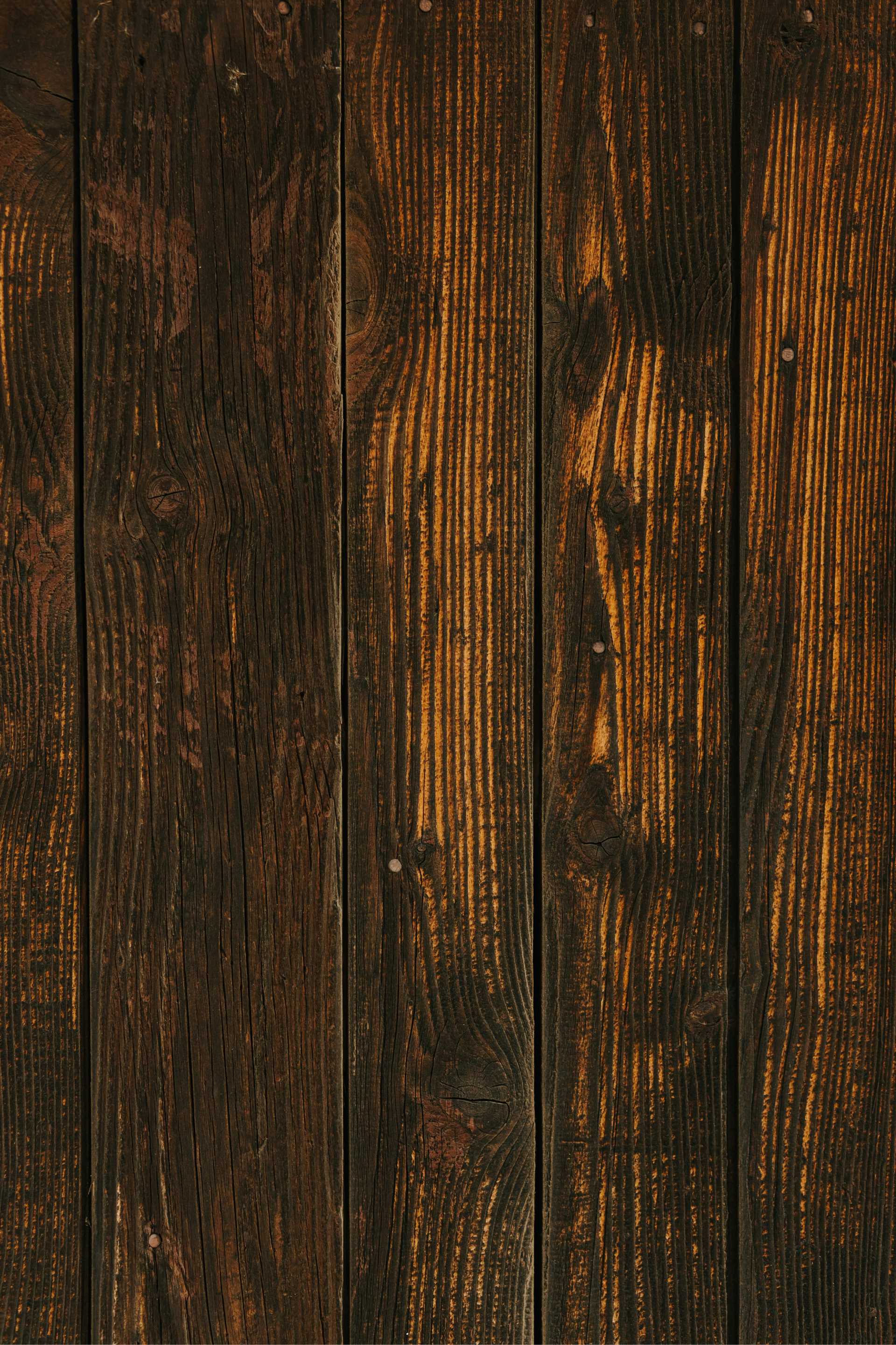 Close-up of dark brown wooden planks with visible grain patterns and nails.